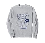 Ce design fantaisiste captive avec son interprétation humoristique du passage du temps, avec un personnage de réveil animé signifiant un vieillissement rapide avec un texte ludique déclarant bien en évidence « I BLINKED & 30 YEARS FLEW BY » sur un fond sombre, accompagné de la