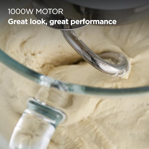 A close-up of the Kenwood kMix pâtisserie set including the K-beater, whisk, and dough hook resting next to the mixer.