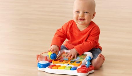 Child playing with the VTech Sing and Discover Story Piano on the floor