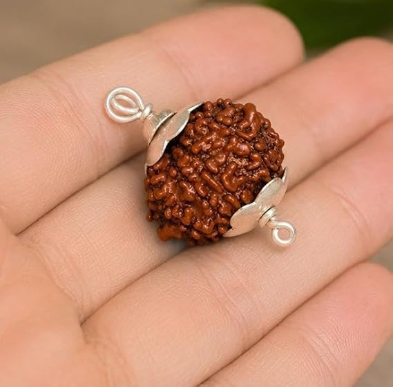 The 9 Mukhi Rudraksha Locket is a traditional spiritual pendant featuring a natural 9 Mukhi Rudraksha bead. In traditional beliefs, it is associated with Goddess Durga and represents strength, courage, and spiritual devotion. Designed with an elegant look, this locket is suitable for daily wear, meditation, prayer, and devotional practices. It is नौ मुखी रुद्राक्ष लॉकेट एक पारंपरिक आध्यात्मिक पेंडेंट है जिसमें एक प्राकृतिक नौ मुखी रुद्राक्ष का मनका लगा हुआ है। पारंपरिक मान्यताओं में, इसे देवी दुर्गा से जोड़ा जाता है और यह शक्ति, साहस और आध्यात्मिक भक्ति का प्रतीक है। सुरुचिपूर्ण ढंग से डिज़ाइन किया गया यह लॉकेट दैनिक उपयोग, ध्यान, प्रार्थना और भक्तिमय अनुष्ठानों के लिए उपयुक्त है।-image-37