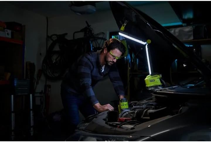 Man working on car engine with Ryobi P727 work light