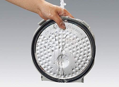 A hand cleaning the detachable inner lid of the Zojirushi rice cooker.