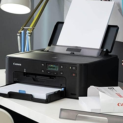 Canon PIXMA TS704a printer in an office setting with paper loaded