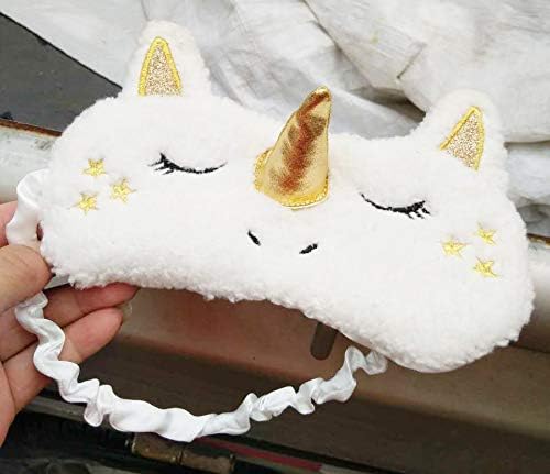 A hand holding a white unicorn sleeping mask, illustrating the elastic band and soft material.