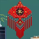 Chinesische Neujahrsdekoration mit roten Knoten, Quasten und roten Dekorationen. Jeder chinesische Knoten wird mit einem Seil gebunden und sieht nach der Fertigstellung von vorne und hinten gleich aus. Seine Symmetrie entspricht den ästhetischen Ansprüchen der Chinesen. Rot symbolisiert Glück und Wohlstand.
