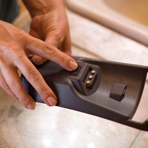 A hand pressing the release button on a detachable LED panel of the Coleman Quad LED Lantern.