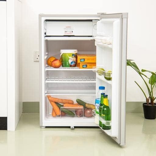 Interior view of the Geepas refrigerator with various food items stored on shelves and in door baskets.