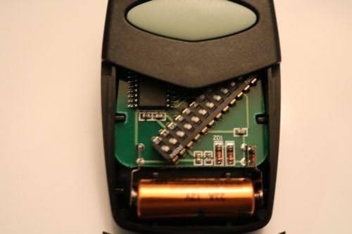 ภาพระยะใกล้ view ภาพแสดงแผงวงจรภายในของรีโมทที่ใช้งานร่วมกับ Genie ได้ โดยแสดงสวิตช์แบบ DIP 12 ตัวและแบตเตอรี่