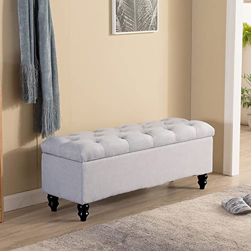 Banc de rangement tapisse en lin au pied du lit pour organiser la chambre