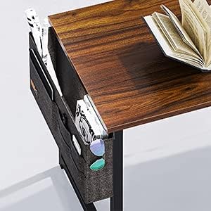 Close-up view of the desk's side storage bag, showing multiple compartments holding books, magazines, and sunglasses.