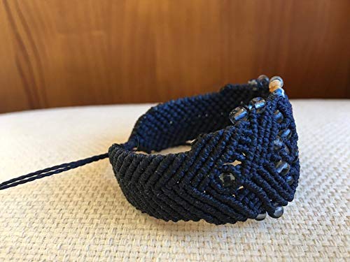 Brazalete macrame hecho a mano con hilo encerado color azul marino y detalles en contraste. Cierre ajustable.