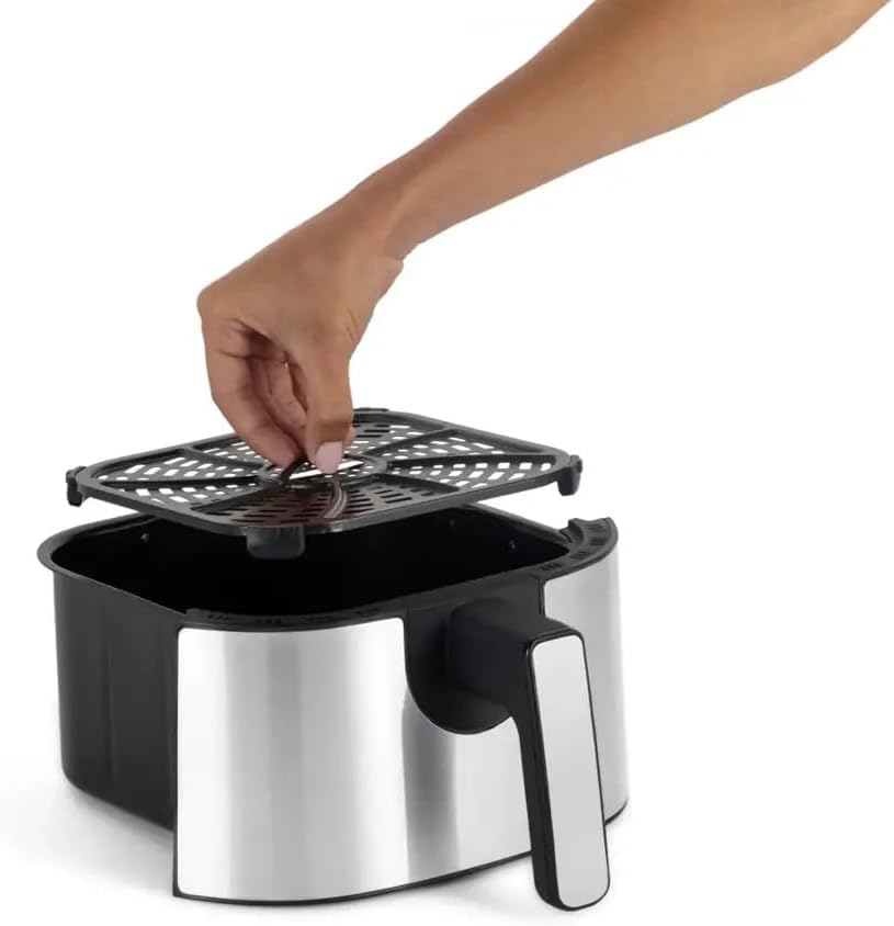 Hand placing crisping tray into air fryer basket