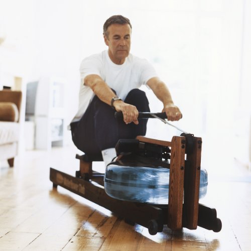 Senior man working out at home on a WaterRower Club Rowing Machine