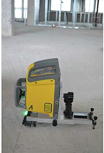 The SPECTRA PRECISION HV302G-1 Green Beam Rotary Laser placed on a low-profile floor stand, emitting a green laser line across a concrete floor in an indoor construction setting.