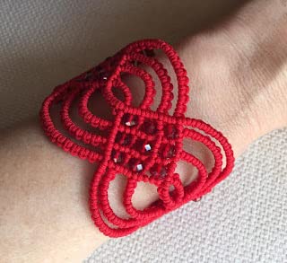 Brazalete ancho rojo macramé hecho a mano con cuentas de cristal a juego.Mide aprox.18 cm. de largo y 5 cm. de ancho.Cierra con botón