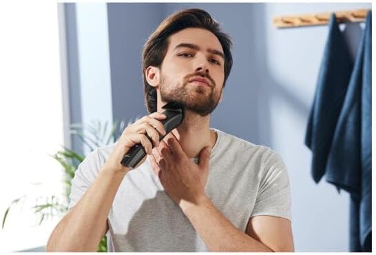 Uomo che usa il tagliacapelli sulla barba