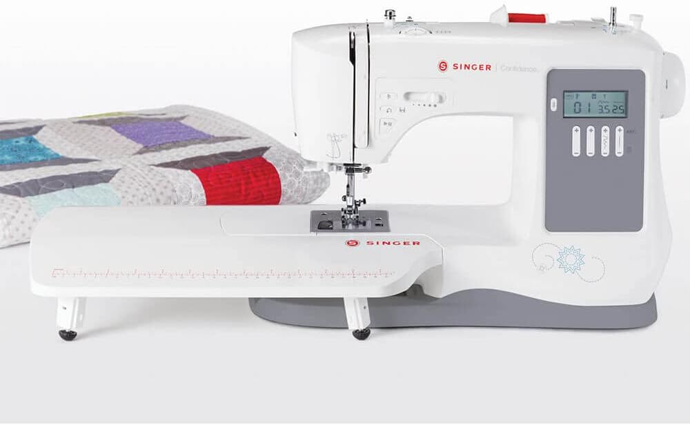 SINGER 7640 sewing machine with extension table attached, next to a quilt