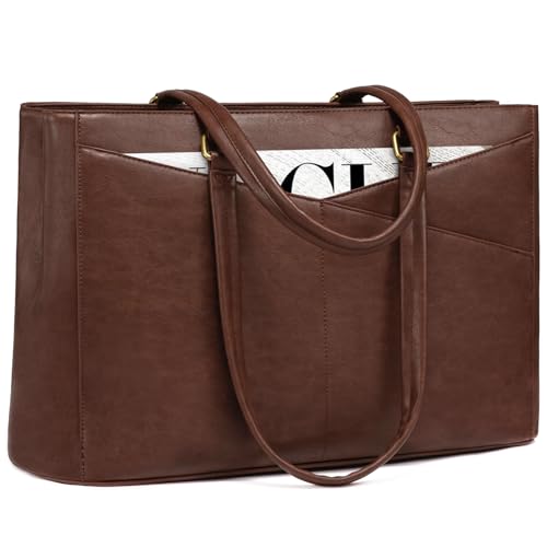 a structured leather tote standing upright beside a desk with a laptop edge showing
