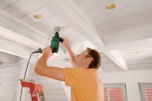 Man using Bosch impact drill to drill into a wooden ceiling beam