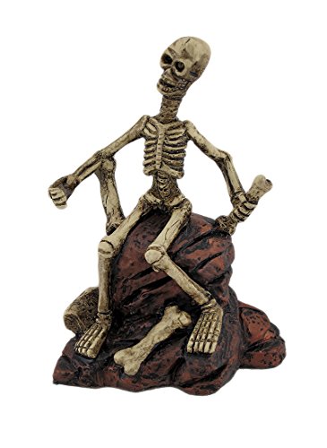 Figura Estatua esqueleto sentado sobre rocas