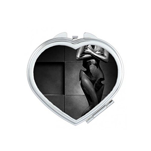 Miroir compact noir cassé avec sculpture de coeur et silhouette nue féminine