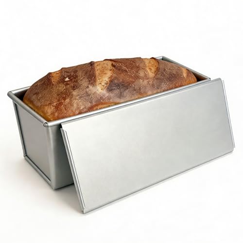 Baker slicing soft white bread on a clean kitchen counter