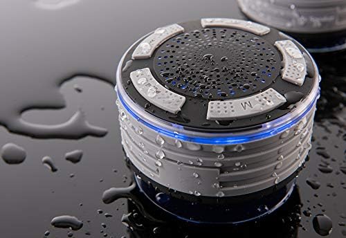 Close-up of a single Sharper Image shower speaker on a wet black surface, with blue light, showing the control buttons.