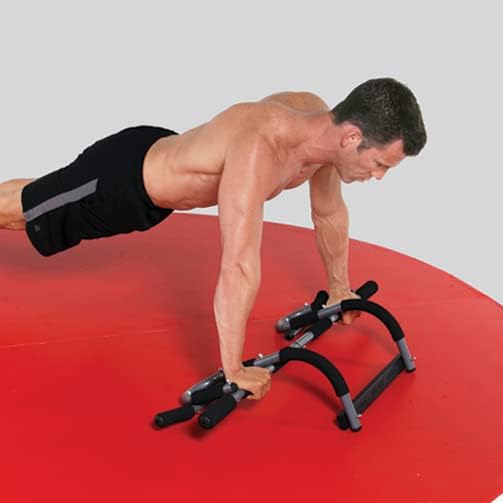 Man performing push-ups using the Iron Gym Total Upper Body Workout Bar on the floor.