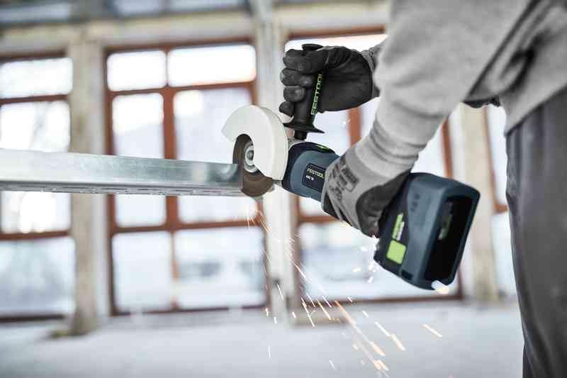Worker using Festool angle grinder to cut metal