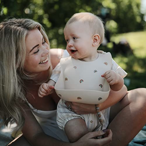 Image of mushie Silicone Baby Bib | Adjustable Fit Waterproof Bibs (Rainbows)
