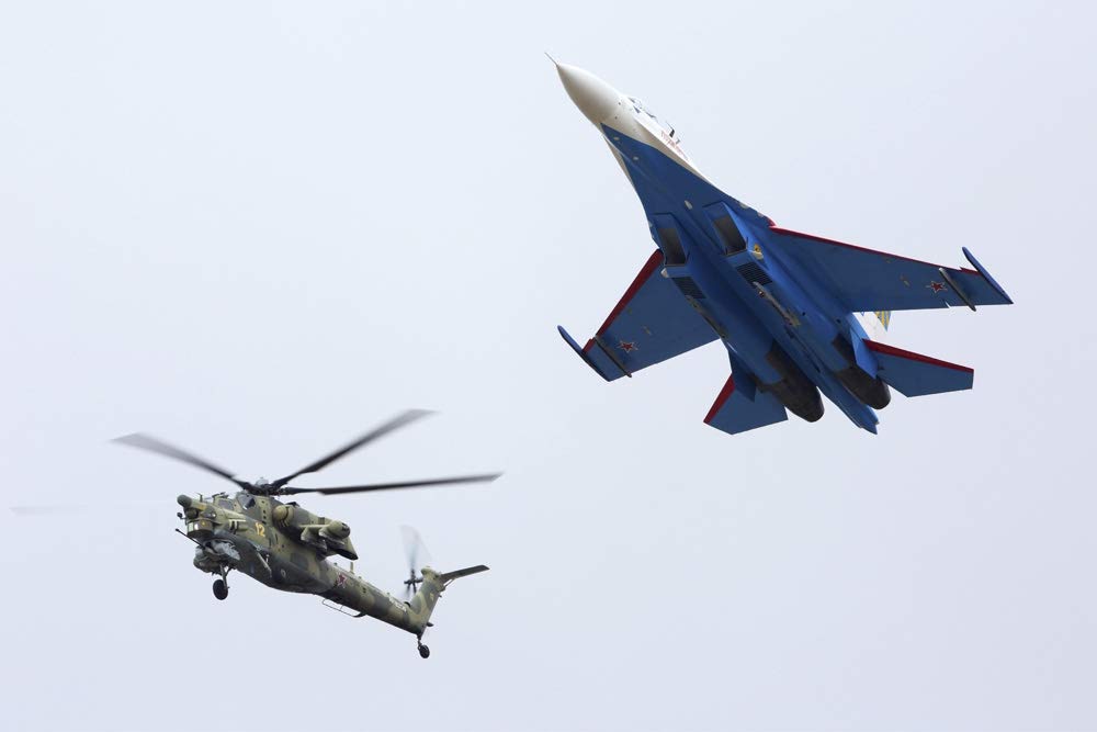 Formation flight of a Russian Su-27 and a Mil Mi-28N helicopter. Poster Print by Artem Alexandrovich/Stocktrek Images (17 x 11)