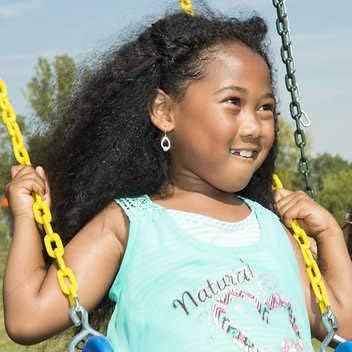 Child on playset swing