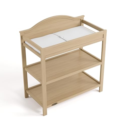 Image of Graco Story Changing Table with Water-Resistant Pad - GREENGUARD Gold Certified Baby Changing Station with Safety Strap, 2 Open Shelves, and a Nursery Must-Have Design (Driftwood)