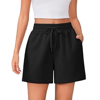A person wearing black PINSPARK Women's Athletic Sweat Shorts with an elastic waistband and drawstring, paired with a white crop top, showcasing the casual and comfortable design with side pockets.