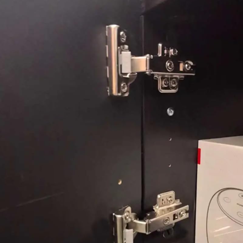 IKEA Besta soft close hinges installed on a dark cabinet door, showing the mechanism in place.