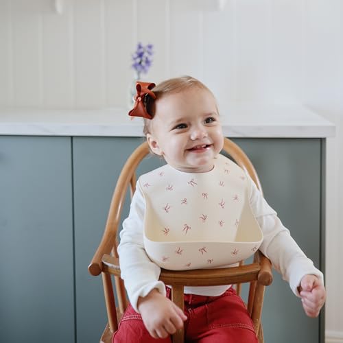 Image of mushie Silicone Baby Bib | Adjustable Fit Waterproof Bibs (Bows)