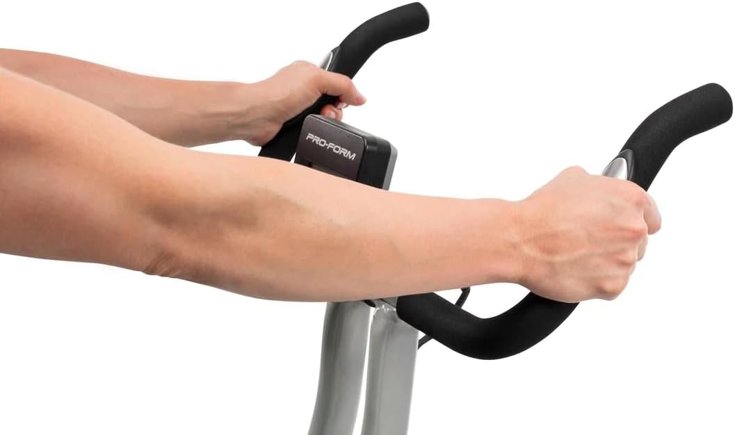 Hænder, der griber fat i EKG-pulssensorerne på ProForm X-cykelstyret