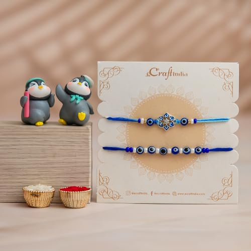 Image of eCraftIndia Designer Blue Evil Eye Rakhi Set of 2 with Best Bro Ever Fridge Magnet & Cute Penguin Showpieces | Roli Chawal Included | Raksha Bandhan Gift for Brother