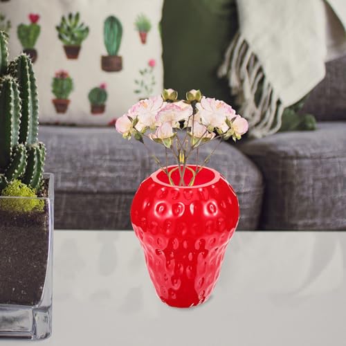Vase en verre rouge fraise contre la déco terne de bureau moderne