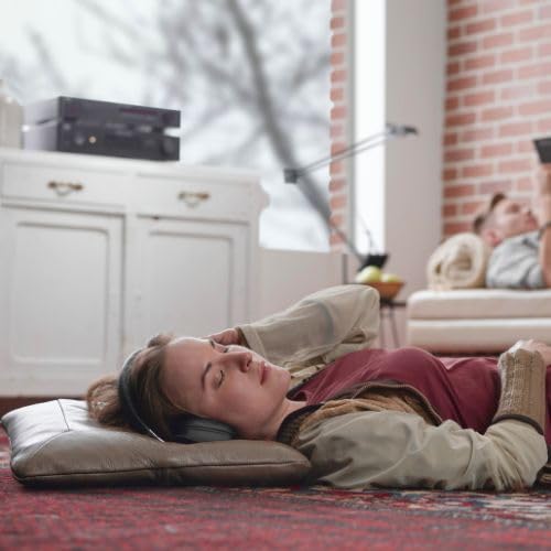 Person listening to music with headphones connected to NAD C 338