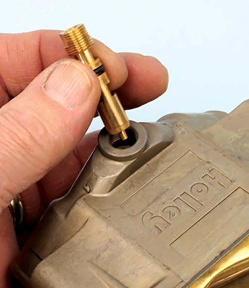 Hand installing a main jet into a Holley carburetor body