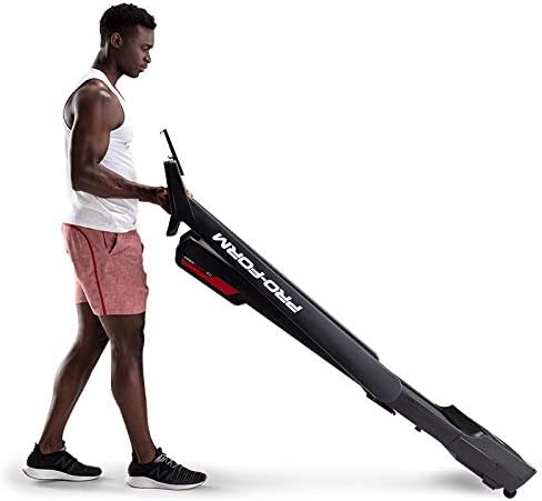 Person folding the ProForm City L6 Treadmill into an upright storage position.