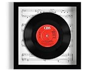 This is the genuine 7” record, raised within the frame, giving a fantastic 3D 'floating' effect. This is surrounded by either plain white cartridge paper or vintage sheet music and a black, white or oak-effect frame, with a clear plastic glass front....