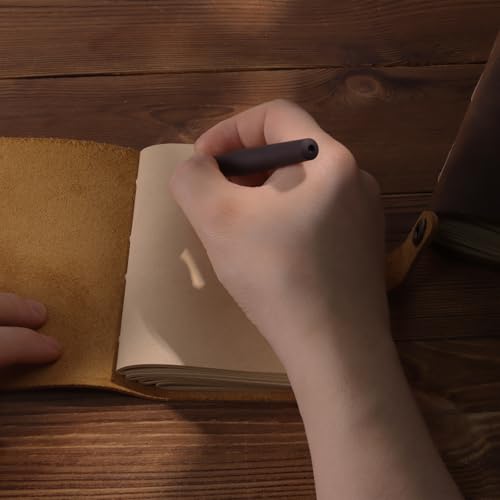 Hand writing a brief note in a small brown notebook