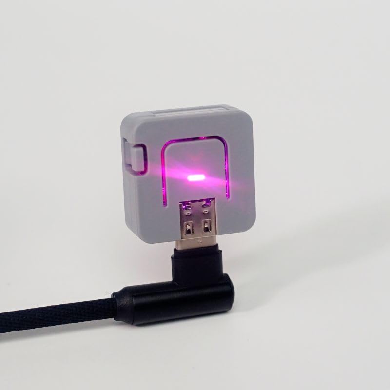 M5Stack ATOM Lite connected via angled USB adapter with RGB LED illuminated