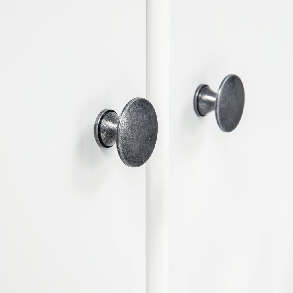 Close-up of a round, dark metal door knob on the white wardrobe door.