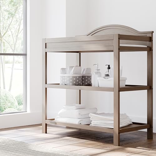 Image of Graco Story Changing Table with Water-Resistant Pad - GREENGUARD Gold Certified Baby Changing Station with Safety Strap, 2 Open Shelves, and a Nursery Must-Have Design (Hazelnut)