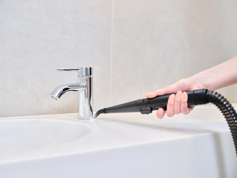 Hand using the conical nozzle to clean around a sink faucet