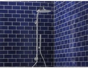 KOHLER HydroRail-R Arch Shower Column in use with water flowing from the rainhead