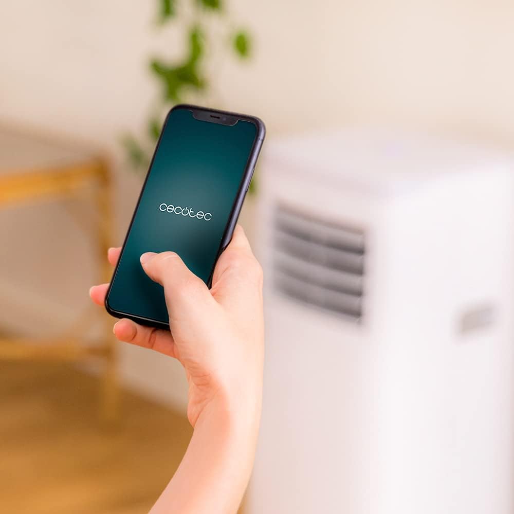 Hand holding a smartphone displaying the Cecotec app for controlling the air conditioner